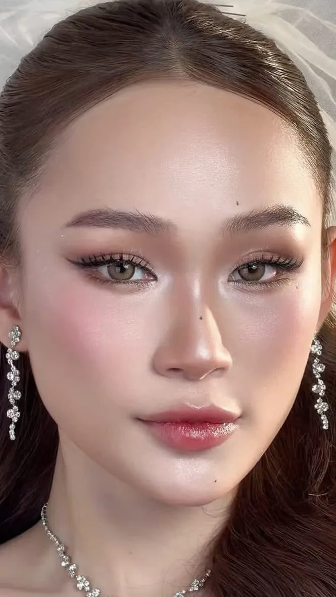 Cận cảnh lớp nền căng mịn, mắt nâu hồng, bông tai đá dài, môi nâu bóng, KINKAY Sài Gòn