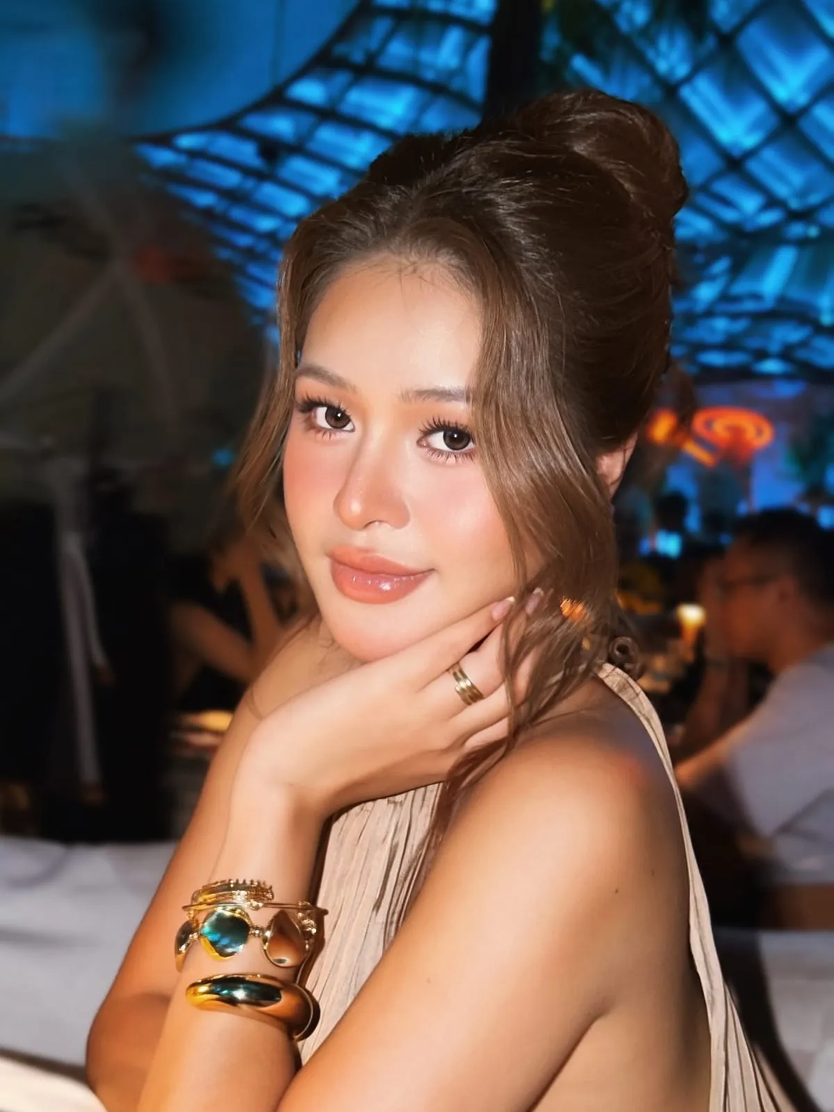 Makeup dự tiệc tông nude hồng, tóc búi cao, váy hai dây be, KINKAY TP.HCM