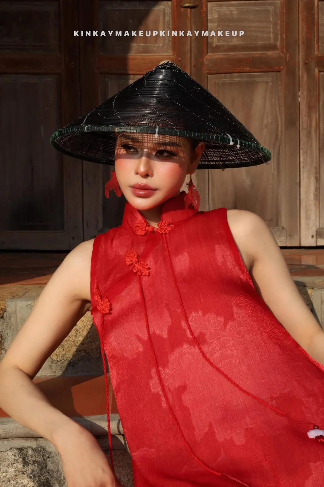 Áo dài đỏ cách tân, nón lá đen, bông tai đỏ, cửa gỗ, KINKAY Sài Gòn