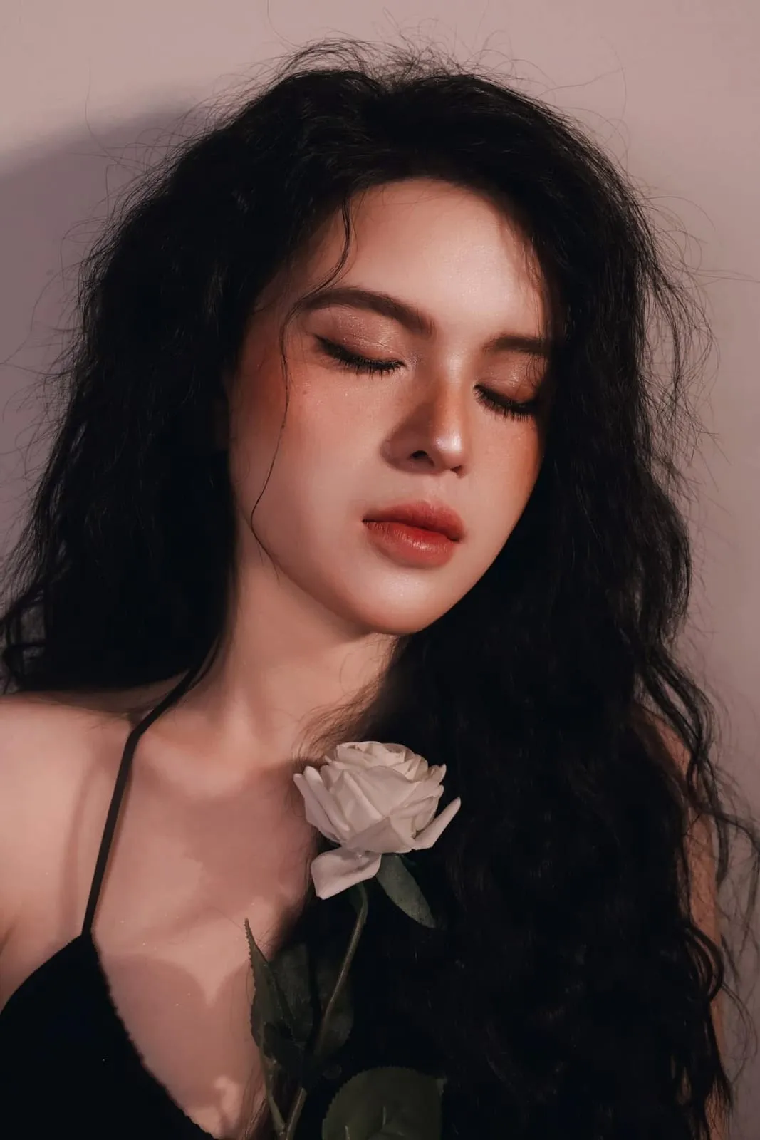 Tóc xoăn phồng, nhắm mắt, makeup tông cam đất, cầm hoa hồng trắng, KINKAY TP.HCM
