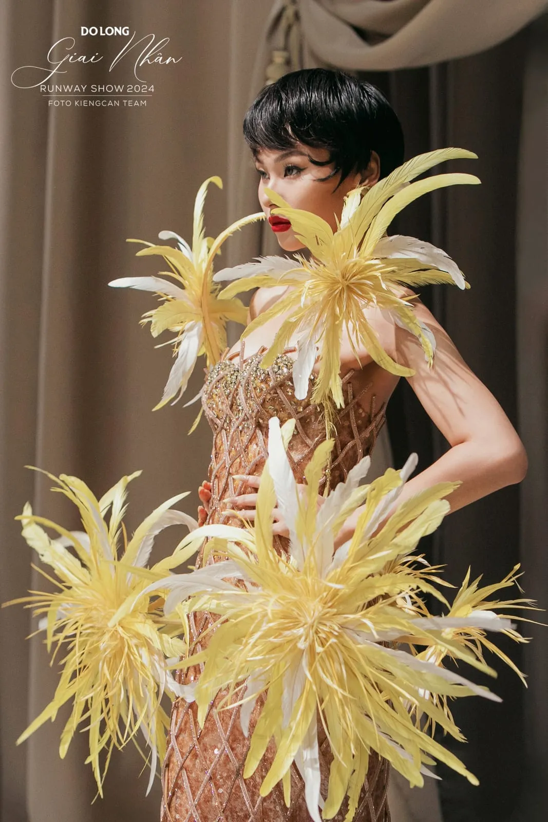 Trang phục lông vũ vàng, tóc pixie đen, son đỏ, chụp hậu trường runway, KINKAY TP.HCM
